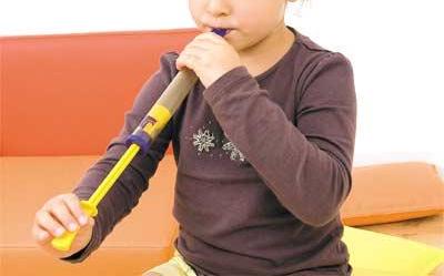 Niño jugando con la flauta de émbolo de madera Montessori