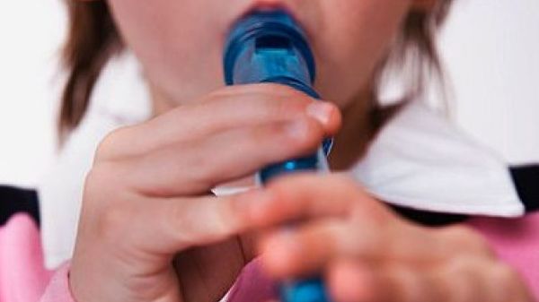 Niño aprendiendo a tocar la flauta dulce de madera con concentración