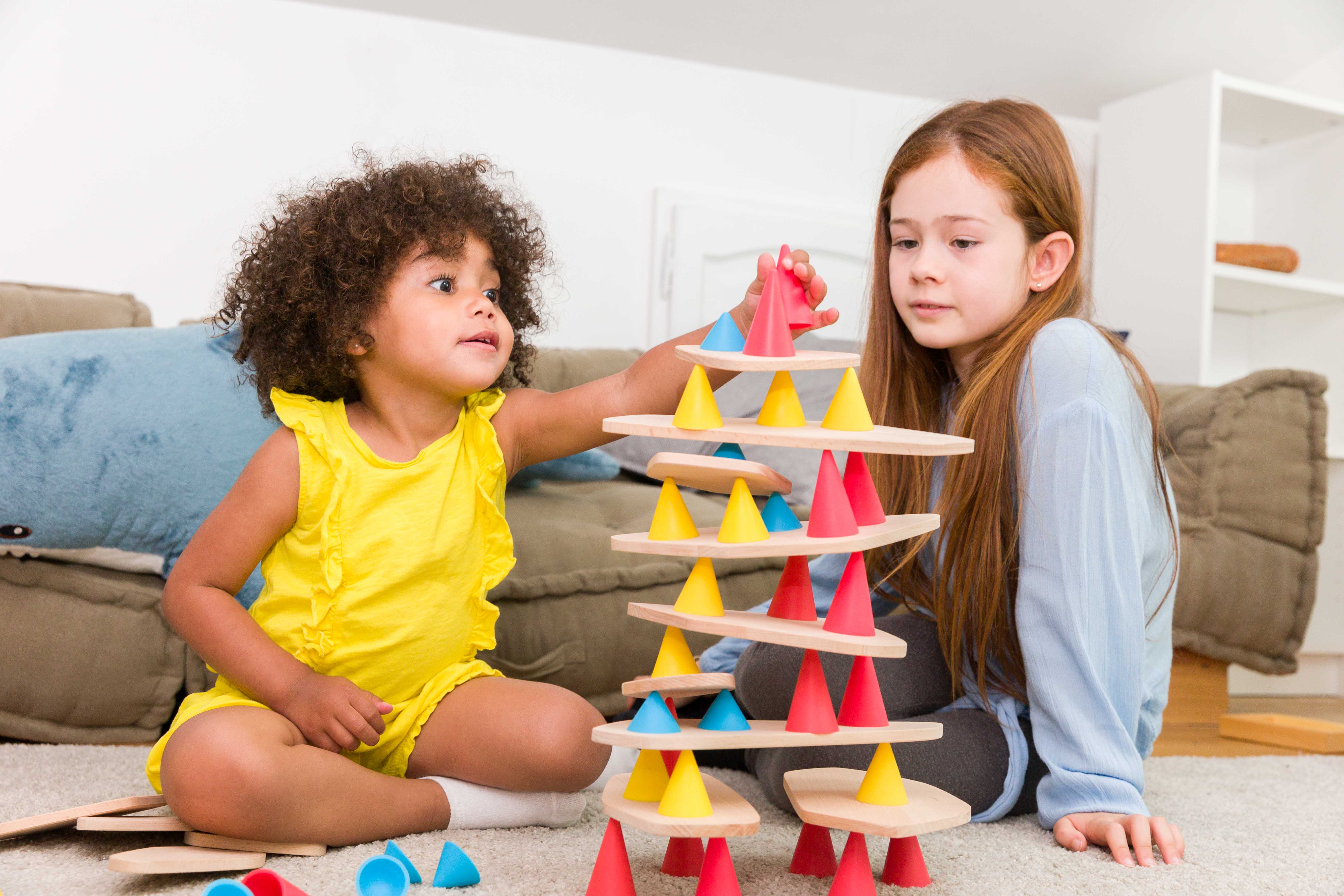 Niño construyendo una torre Piks en equilibrio